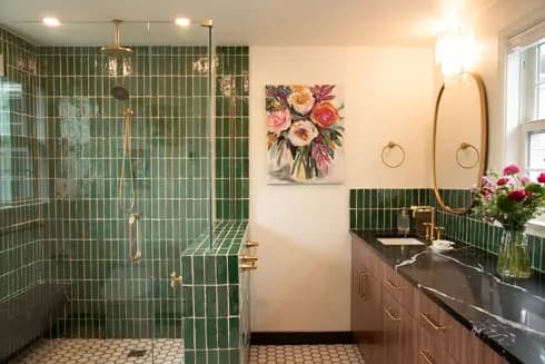 Bathroom with green vertical tile shower and a floral painting